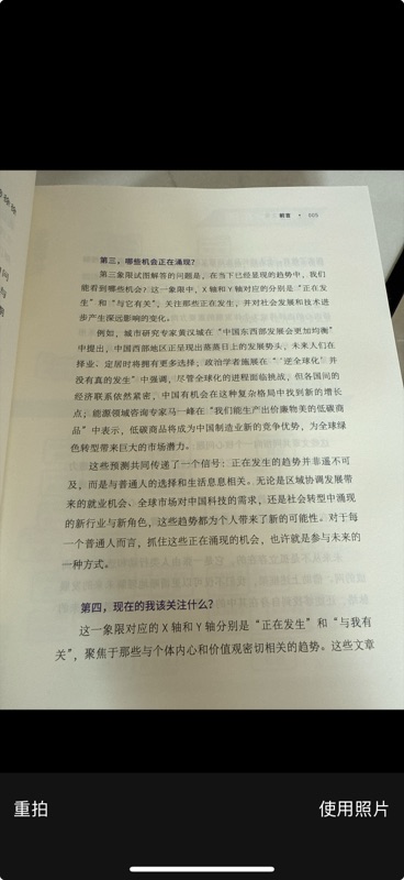 手机相机拍摄界面,对准一本纸质书的书页内容进行拍照,页面底部显示「重拍」和「使用照片」两个操作按钮